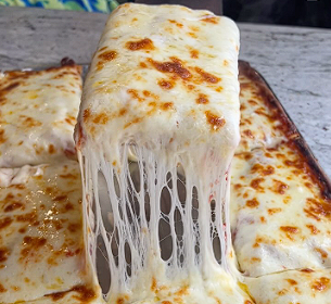 araffy cheese pizza being lifted from a pan with a spatula