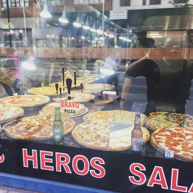 there are many pizzas on display in a window of a restaurant