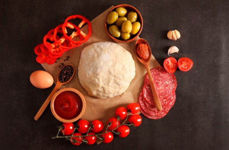 there is a pizza dough with ingredients on a table