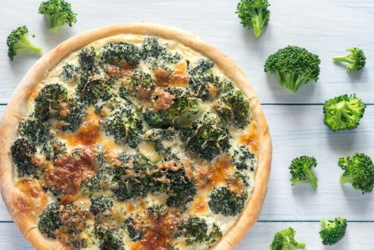 there is a pizza with broccoli and cheese on a table