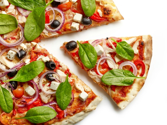 there are four slices of pizza with different toppings on a white surface