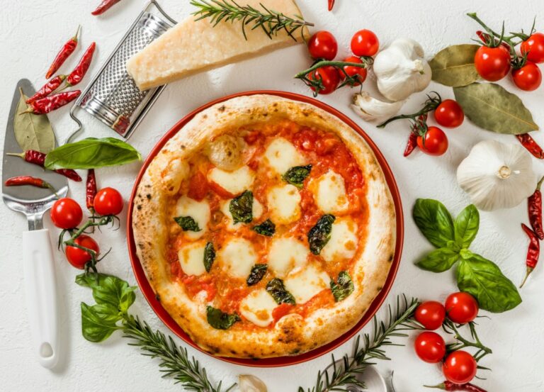 a close up of a pizza with cheese and tomatoes on a table